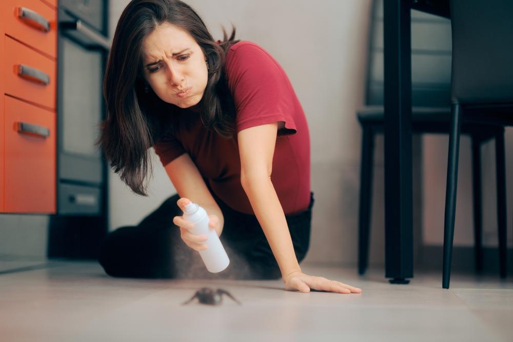 Woman,Spraying,With,Insecticide,Over,An,Ant,On,The,Kitchen